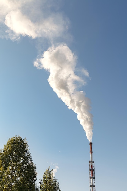 Lage hoek van de rook uit de schoorsteen tegen de lucht