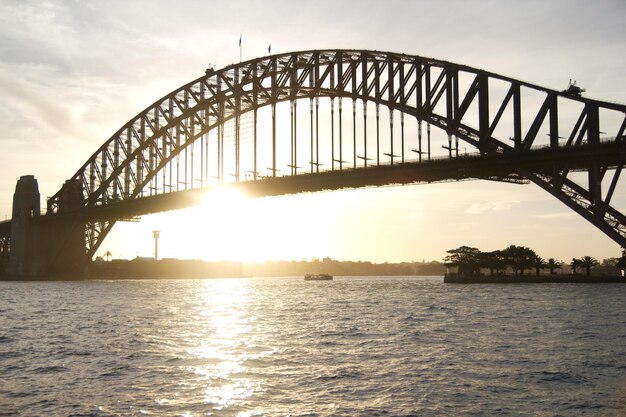 Foto lage hoek van de sydney harbour bridge over de rivier tijdens de zonsondergang