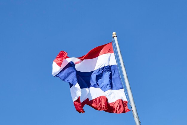 Foto lage hoek van de thaise vlag tegen een heldere blauwe lucht