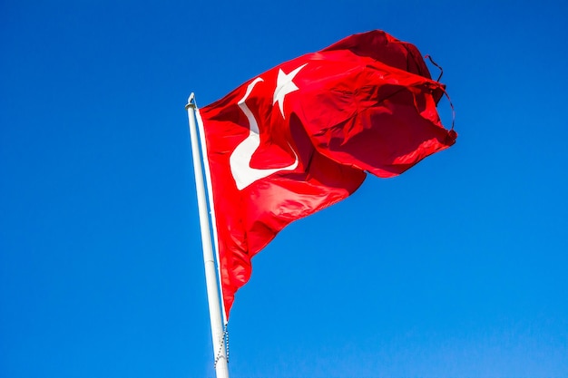 Lage hoek van de Turkse vlag tegen een heldere blauwe lucht