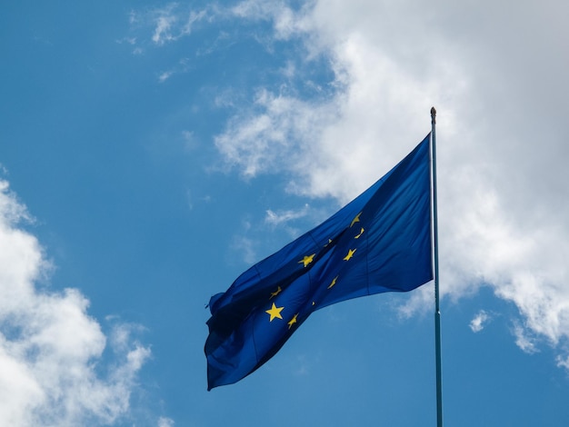 Lage hoek van de vlag van de Europese Unie tegen bewolkte lucht