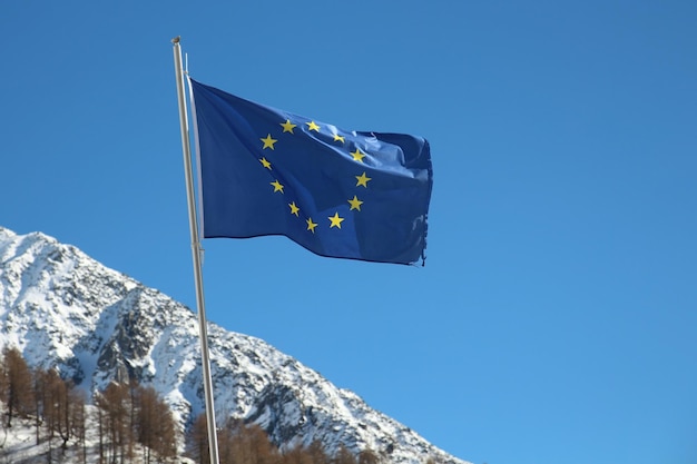 Lage hoek van de vlag van de Europese Unie tegen een besneeuwde berg