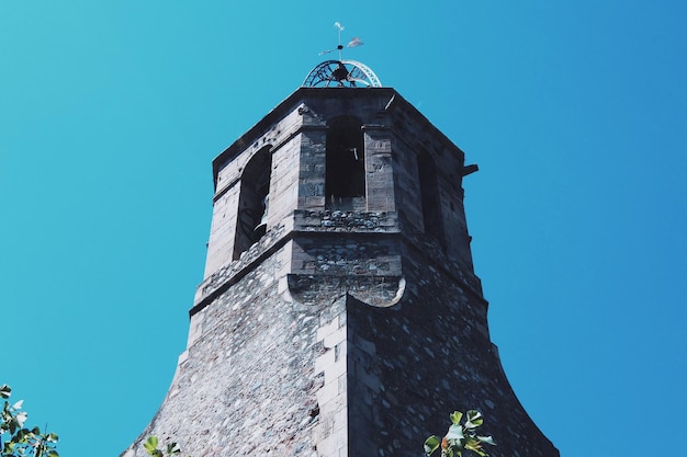 Lage hoek van de weervleugel op de toren tegen een heldere lucht