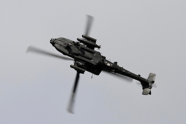 Foto lage hoek van een apache-helikopter die in de lucht vliegt