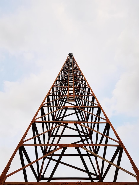 Foto lage hoek van een driehoekige toren tegen een bewolkte lucht