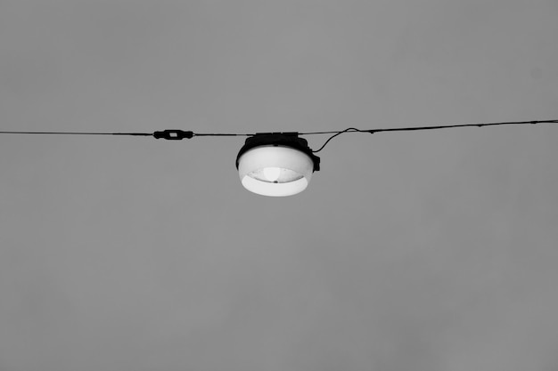 Foto lage hoek van een gloeilamp die tegen de lucht hangt