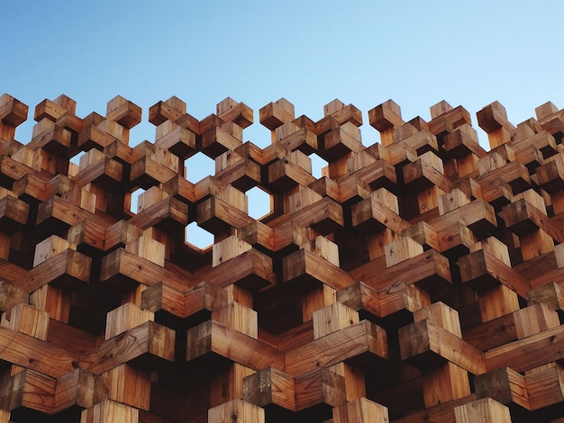 Lage hoek van een houten sculptuur tegen een heldere blauwe lucht