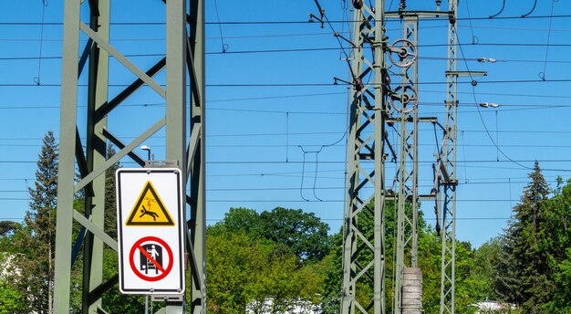 Foto lage hoek van een informatiebord op een elektriciteitspylon tegen een heldere blauwe lucht