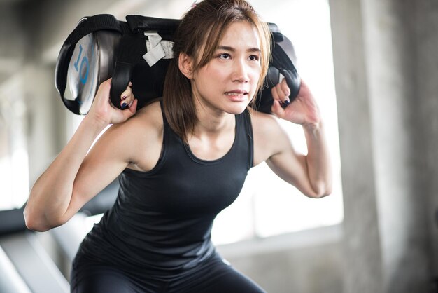 Lage hoek van een jonge vrouw die gewichten tilt in de sportschool