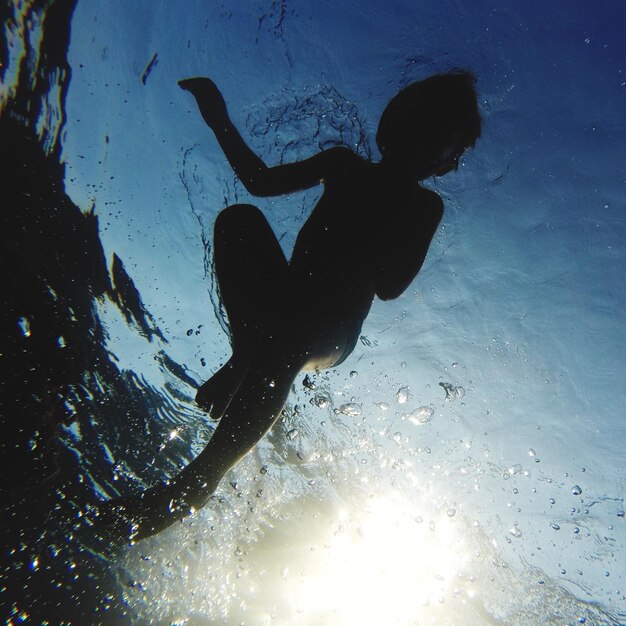 Foto lage hoek van een jongen die in de zee zwemt