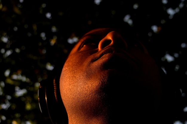 Foto lage hoek van een man die naar muziek luistert tegen bomen