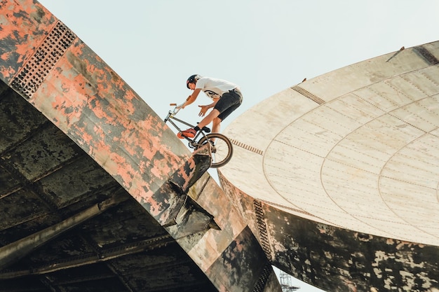 Foto lage hoek van een man die op een fiets rijdt op een satellietschotel