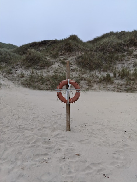 Foto lage hoek van een man die op het strand loopt tegen de lucht