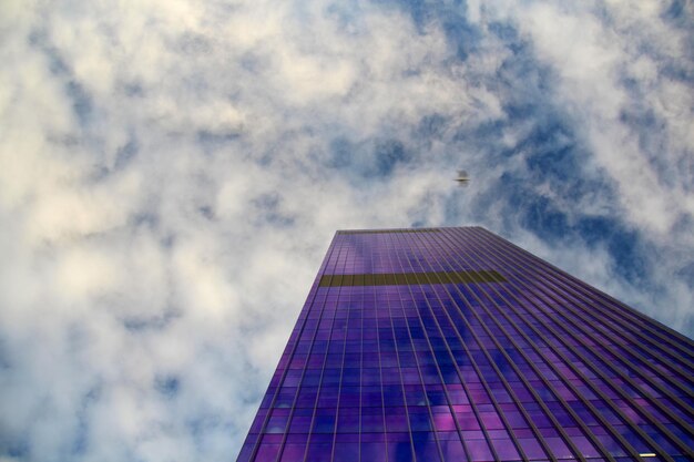 Lage hoek van een modern gebouw tegen een bewolkte lucht