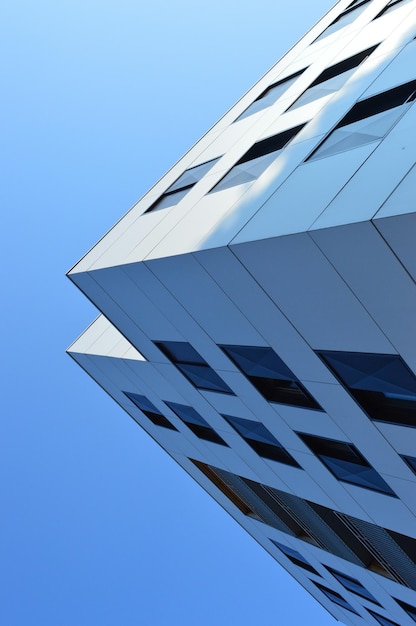 Lage hoek van een modern gebouw tegen een heldere blauwe lucht