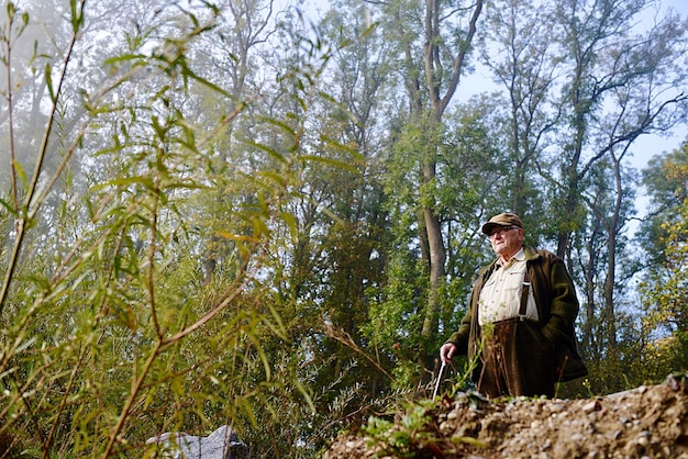 Lage hoek van een oudere man die in het bos staat