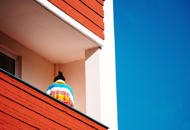 Lage hoek van een persoon die op het balkon van een gebouw staat