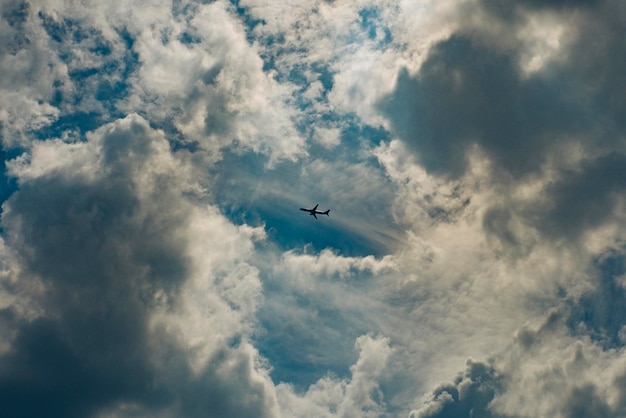 Lage hoek van een silhouetvliegtuig dat in de lucht vliegt