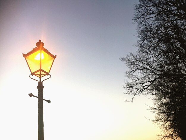 Lage hoek van een verlichte lantaarnpaal tegen de lucht