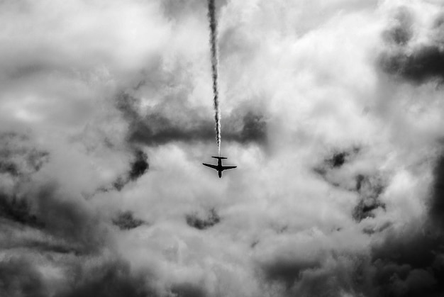 Foto lage hoek van een vliegtuig dat in een bewolkte lucht vliegt