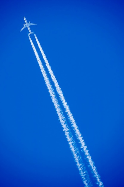 Foto lage hoek van een vliegtuig dat tegen de blauwe hemel vliegt