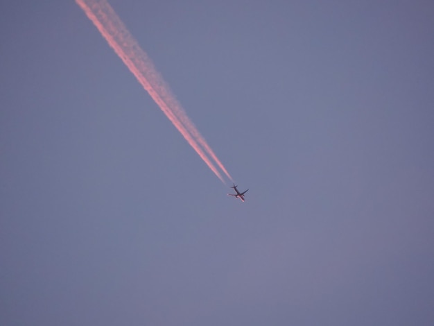 Foto lage hoek van een vliegtuig dat tegen een heldere hemel vliegt