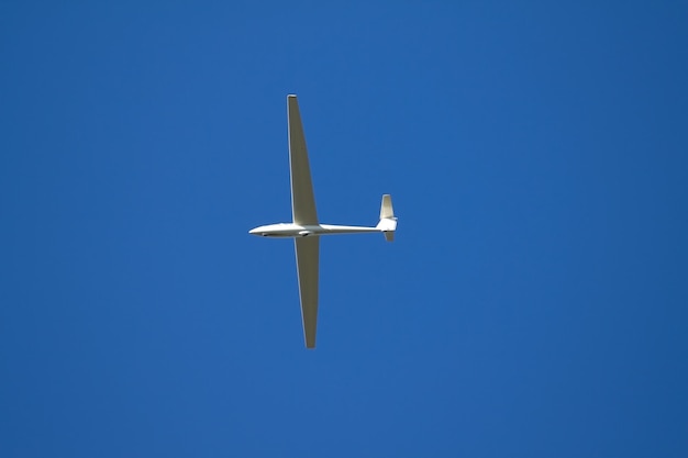 Foto lage hoek van een vliegtuig tegen een heldere blauwe lucht