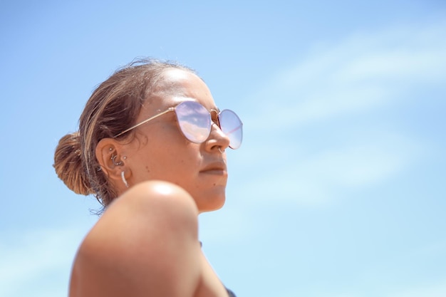Lage hoek van een vrouw met een zonnebril tegen de lucht
