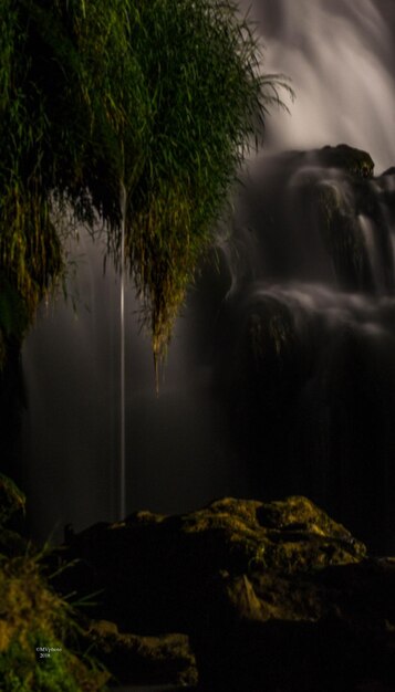 Foto lage hoek van een waterval in het bos's nachts