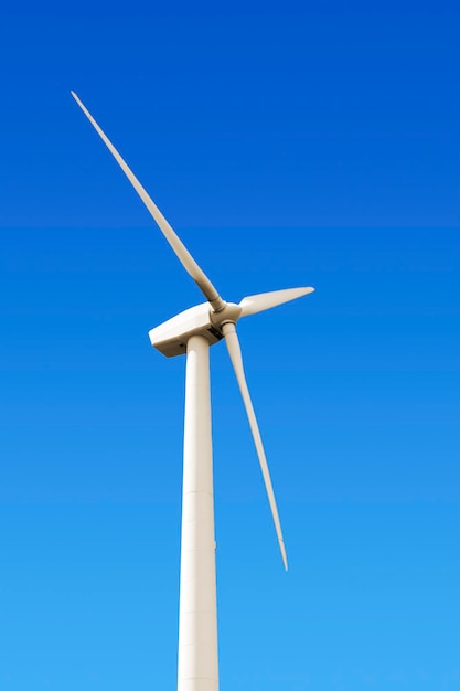 Lage hoek van een windmolen tegen een heldere blauwe lucht