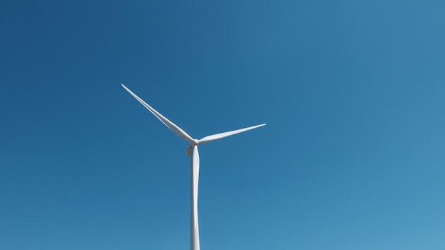 Lage hoek van een windmolen tegen een heldere blauwe lucht