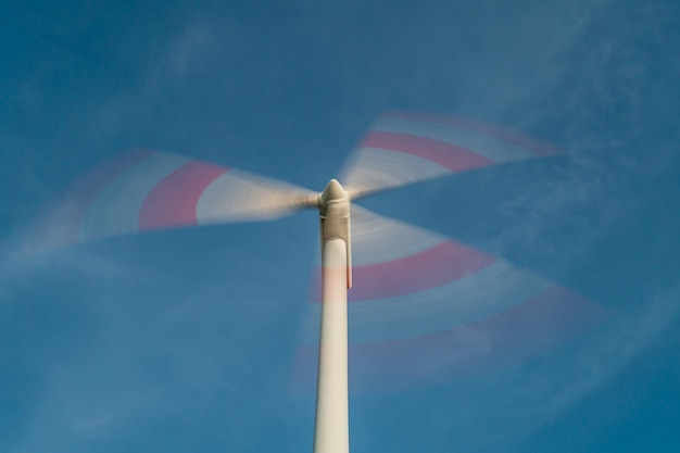 Foto lage hoek van een windturbine tegen een blauwe hemel