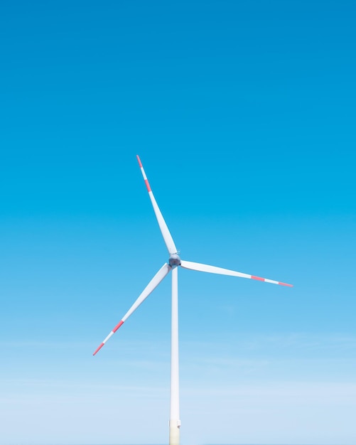 Lage hoek van een windturbine tegen een heldere blauwe lucht