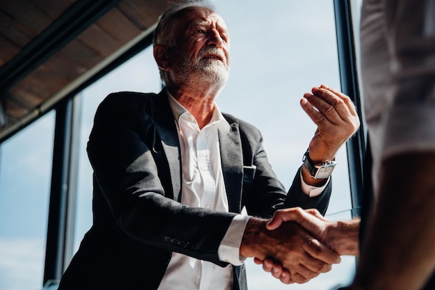 Foto lage hoek van een zakenman die de hand schudt tijdens een discussie in het kantoor