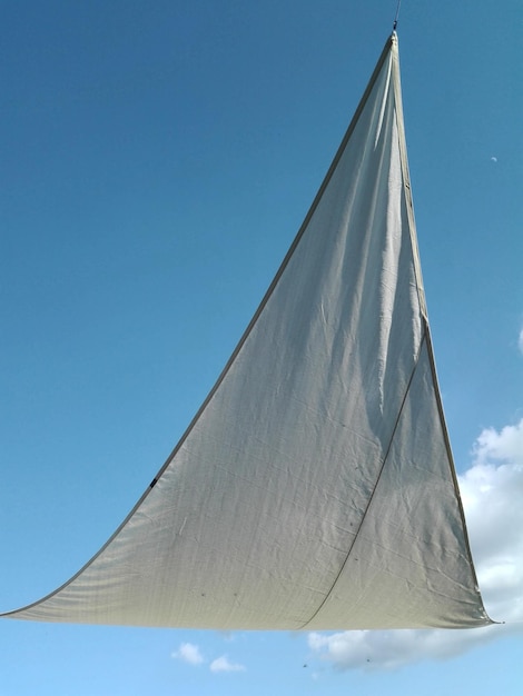 Foto lage hoek van een zeilboot tegen een heldere blauwe lucht