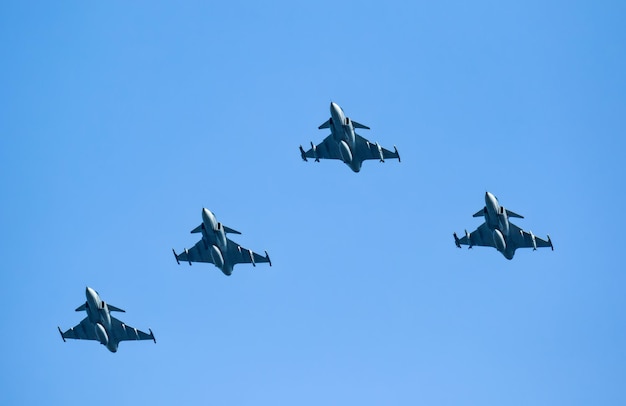 Lage hoek van gevechtsvliegtuigen die tegen een heldere lucht vliegen