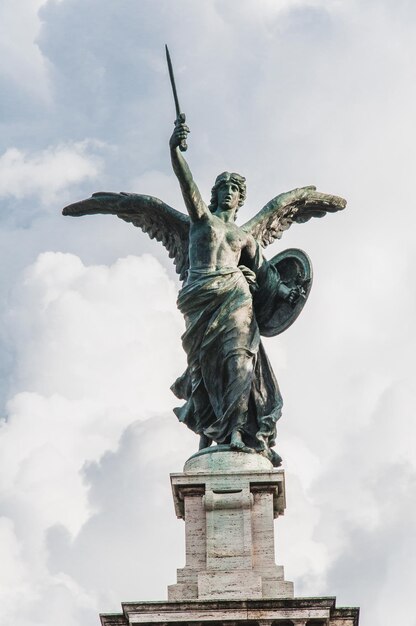 Lage hoek van het engelenbeeld tegen een bewolkte hemel