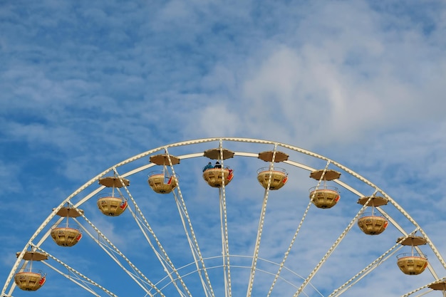 Lage hoek van het reuzenrad tegen de blauwe hemel tijdens een zonnige dag
