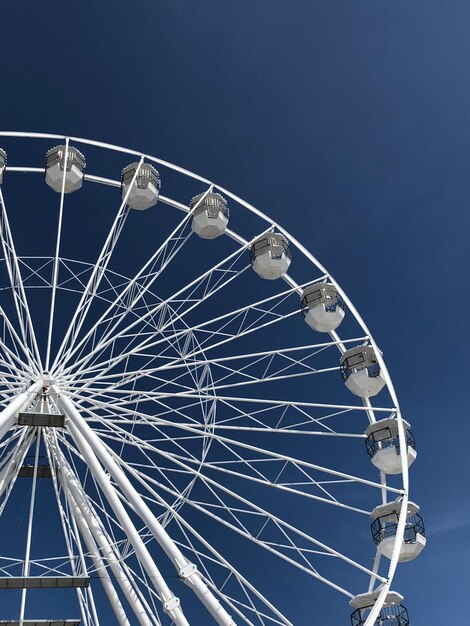 Foto lage hoek van het reuzenwiel tegen een heldere blauwe hemel