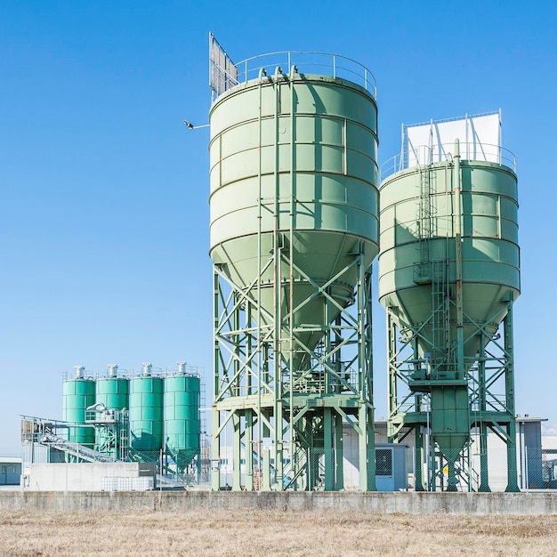 Lage hoek van industriële silo's tegen een blauwe hemel