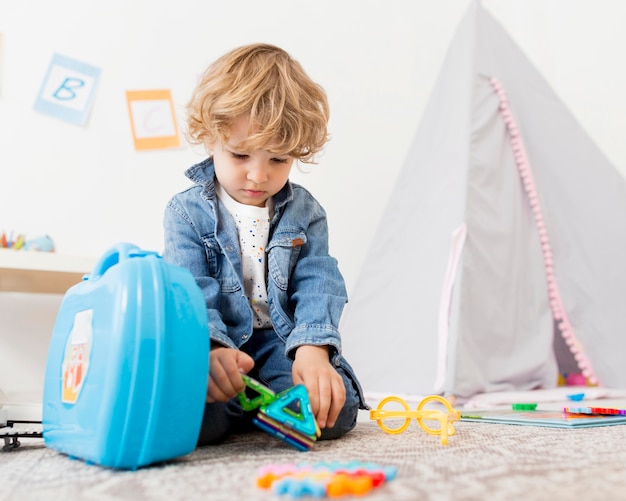 Lage hoek van jongen het spelen met speelgoed thuis