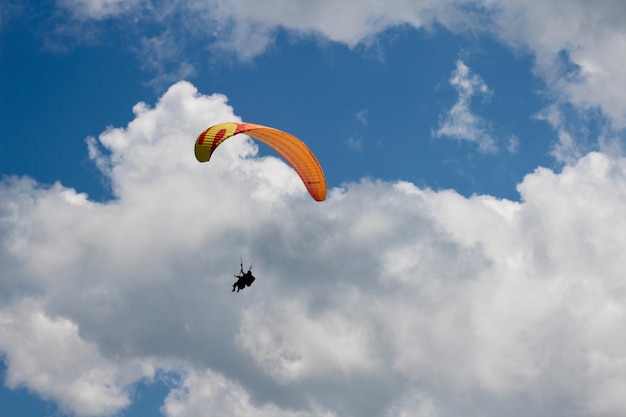 Lage hoek van mensen die tegen de lucht paragliden