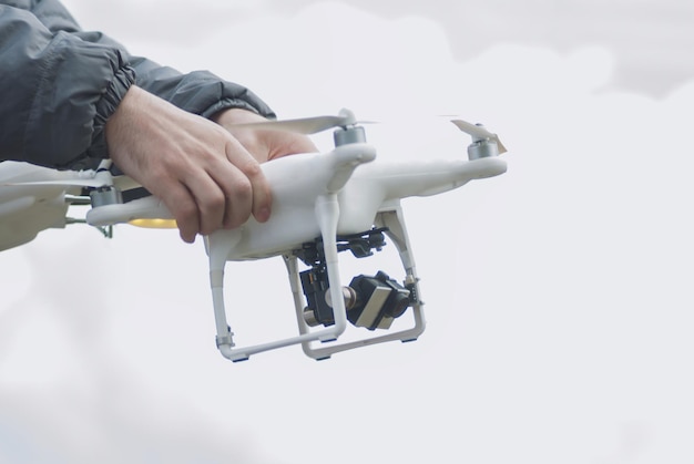 Foto lage hoek van persoon die drone vasthoudt tegen de lucht
