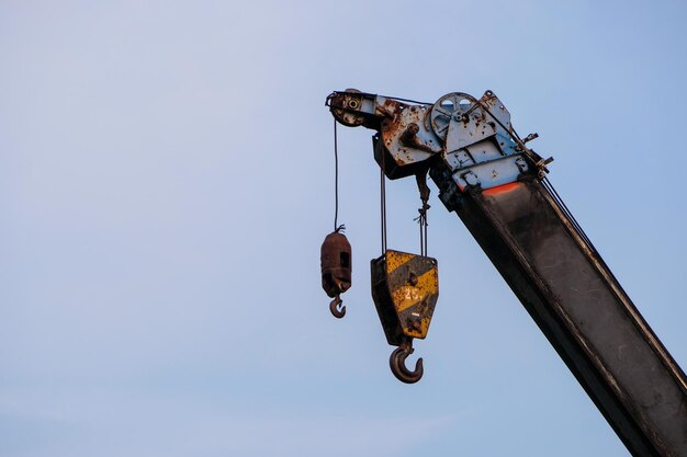 Lage hoek van roestige metaal die tegen een heldere lucht hangt