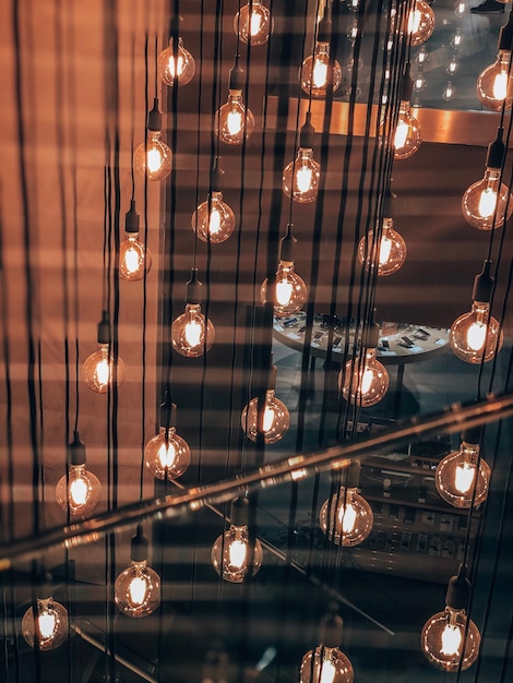 Foto lage hoek van verlichte hanglampen die van het plafond hangen