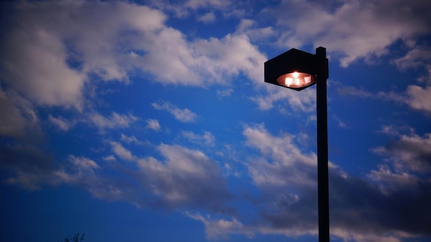 Foto lage hoek van verlichte straatverlichting tegen de hemel in de schemering