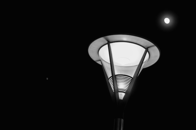 Lage hoek van verlichte straatverlichting tegen de hemel's nachts