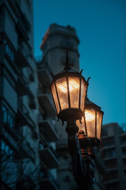 Lage hoek van verlichte straatverlichting tegen een gebouw's nachts