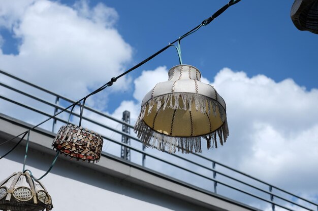 Foto lage hoek van verschillende lantaarns die tegen een bewolkte hemel hangen