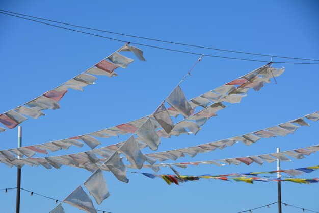 Foto lage hoek van vlaggen die tegen een heldere blauwe hemel hangen